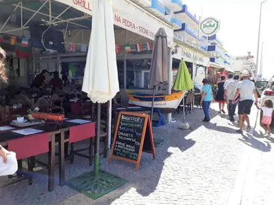 a market with umbrellas and people walking on a street at Solaris- Familiar, Wifi, Totalmente Equipado in Quarteira