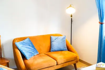 an orange couch with two blue pillows on it at Villa Marrachinho in Albufeira