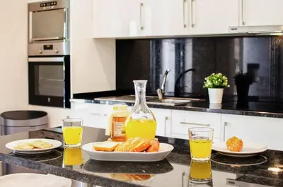 a kitchen counter with a plate of food and orange juice at Villa Redonda in Loulé