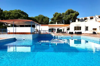 a swimming pool with blue water in front of a building at Albufeira Jardim l old town and beach - Hawai in Albufeira