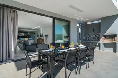 a dining room and living room with a table and chairs at Colinas do Golfe Vilamoura Sun by SAPvillas in Vilamoura