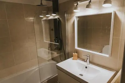 a bathroom with a sink and a shower and a mirror at Soleil Apartment in Quarteira