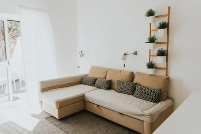 a couch in a living room with plants on the wall at Soleil Apartment in Quarteira