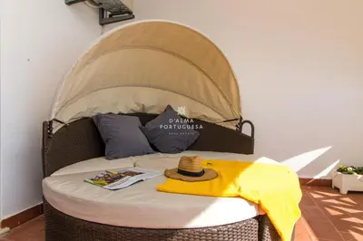 a bed with a hat sitting on top of it at Apartment Aveiros Beach- D´Alma Amado in Albufeira