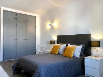 a bedroom with a large bed with yellow pillows at Albufeira I old town and city center in Albufeira