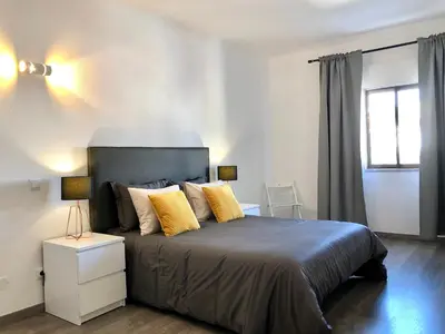a bedroom with a large bed with yellow pillows at Albufeira I old town and city center in Albufeira