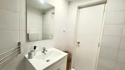 a white bathroom with a sink and a mirror at Cozy and Stylish Studio Apt - just 800m from the beach in Albufeira