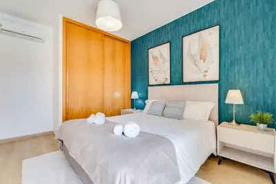 a kitchen with green cabinets and a sink and a window at Sunny Marina View Apartment Albufeira 1B-3C in Albufeira