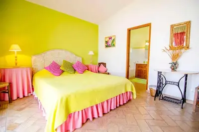 a bedroom with a large bed with pink and yellow sheets at Elegant Villa in Loulé with Private Pool in Loulé