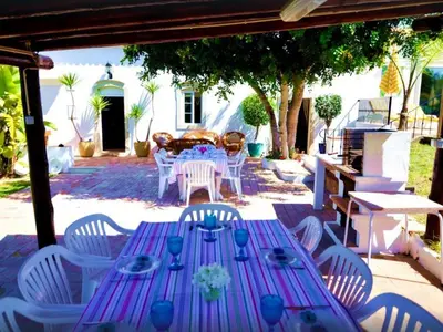 a purple table and white chairs and a table and chairsearcher at Elegant villa with sea view in Loulé + private pool in Loulé
