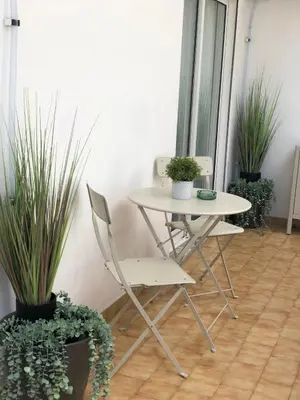 a table and chairs in a room with potted plants at Albufeira Emblematica Apartment - Wifi & Pool in Albufeira