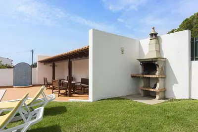 a white house with a fireplace in the yard at Vila de Santa Eulália - Albufeira in Albufeira