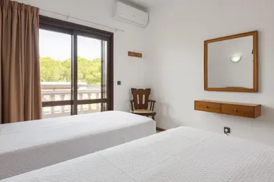 a bedroom with two beds and a mirror and a window at Vila de Santa Eulália - Albufeira in Albufeira