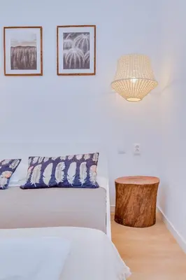 a white bedroom with a bed and a table at Groundfloor in Faro