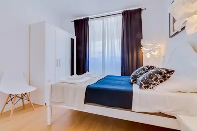a bedroom with a white bed with blue sheets and a window at Groundfloor in Faro