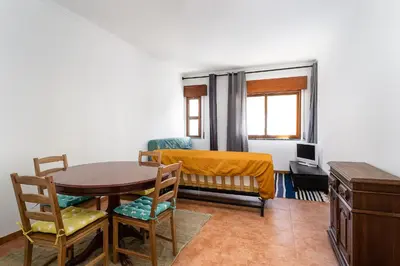 a room with a table and a bed and a desk at Casa Bela in Faro
