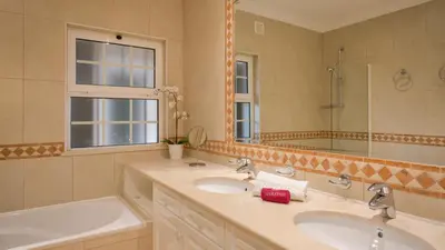 a bathroom with two sinks and a tub and a mirror at Joanne in Vale do Lobo