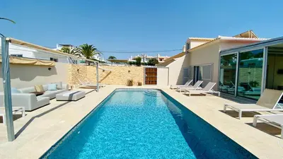 a swimming pool with lounge chairs and a house at Otto by Check-in Portugal in Quarteira
