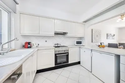 a white kitchen with white cabinets and a sink at Apartament Portes Balaia Golf Resort in Albufeira