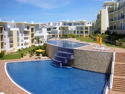 a swimming pool in front of some apartment buildings at Bright apartment with sea view in Albufeira - 62 m², Pool in Albufeira