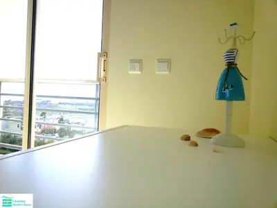 a living room with a glass table and blue chairs at Bright apartment with sea view in Albufeira - 62 m², Pool in Albufeira