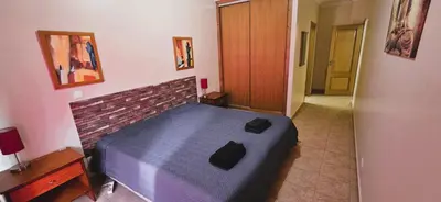 a bedroom with a bed and a desk and a window at Open Space - Albufeira in Albufeira