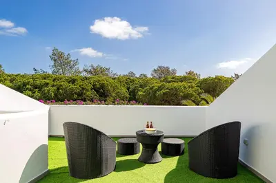 a patio with a table and chairs on grass at Casa Maya - Vale do Garrão in Quinta do Lago