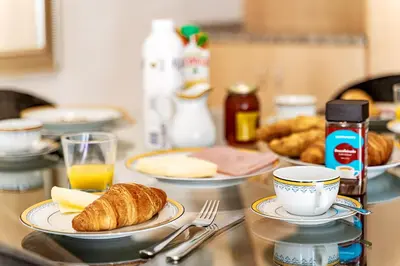 a table with plates of croissants and a cup of orange juice at Casa Maya - Vale do Garrão in Quinta do Lago