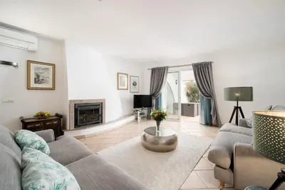 a living room with a couch and a fireplace at Casa Maya - Vale do Garrão in Quinta do Lago