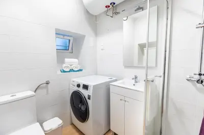 a white bathroom with a washing machine and a sink at Faro Downtown Ria Formosa I in Faro