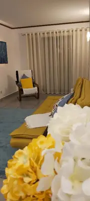 a living room with a bed and flowers on the floor at Casa Senhora da Ria- localização perfeita em Faro in Faro