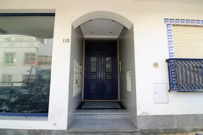 a black door on the side of a building at Odete Túnel - Albufeira in Albufeira