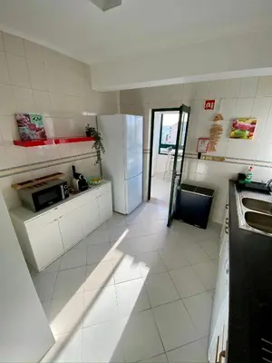 a kitchen with a refrigerator and a counter top at CosyAvenida Mar, 2 rooms in Quarteira
