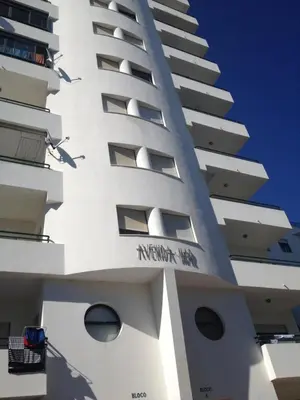 a tall white building with the words meridian on it at CosyAvenida Mar, 2 rooms in Quarteira