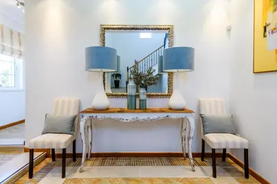a console table with two chairs and a mirror at Endless Summer Luxury Villa in Quinta do Lago