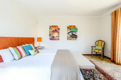 a bedroom with a large white bed with colorful pillows at Endless Summer Luxury Villa in Quinta do Lago