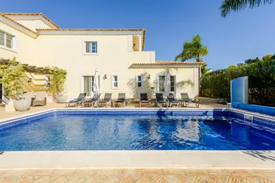 a swimming pool in front of a house at Endless Summer Luxury Villa in Quinta do Lago