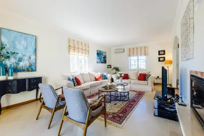 a living room with a couch and a tv at Endless Summer Luxury Villa in Quinta do Lago