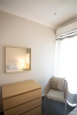 a bedroom with a bed and a chair and a mirror at Aldeia do Mar Studio Vilamoura Center - SWIMMING POOL in Vilamoura