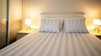 a bedroom with a large bed with two lamps at Aldeia do Mar Studio Vilamoura Center - SWIMMING POOL in Vilamoura