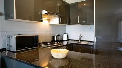 a kitchen with a counter with a microwave and a stove at Aldeia do Mar Studio Vilamoura Center - SWIMMING POOL in Vilamoura