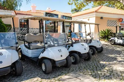 three golf carts parked in front of a house at Villa Simone by Intiholidays in Quarteira