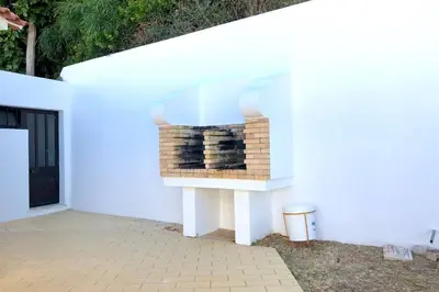 a white house with a brick fireplace on the side of it at Albufeira + appartement proche plage avec piscine in Albufeira