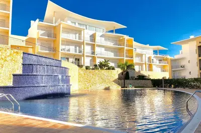 a swimming pool in front of a building at Albufeira l AMAZING terrasse with jacuzzi Encosta da Orada in Albufeira