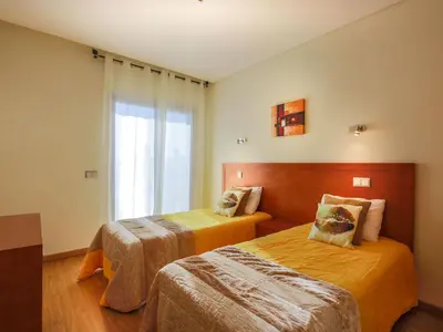 a hotel room with two beds and a window at V4, Villa Jardins Branqueira2 near Beach, Albufeira in Albufeira