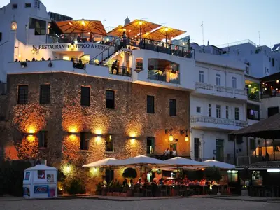 a building with tables and umbrellas in front of it at V4, Villa Jardins Branqueira2 near Beach, Albufeira in Albufeira