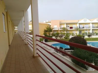 a balcony of a building with a fence and a pool at Salgados Sea View Apartment in Albufeira
