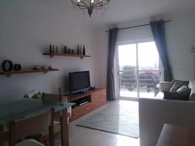 a living room with a tv and a couch and a table at Salgados Sea View Apartment in Albufeira