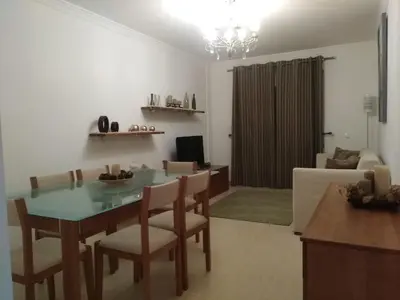 a kitchen and living room with a table and chairs at Salgados Sea View Apartment in Albufeira