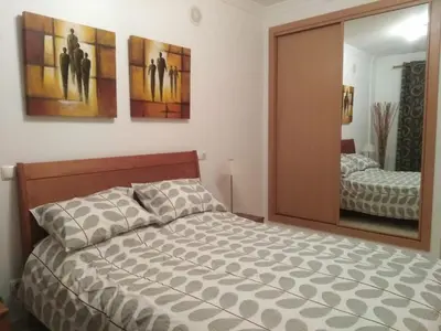 a bedroom with a bed and a large mirror at Salgados Sea View Apartment in Albufeira